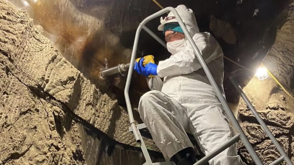 Robyn Barbato del Cold Regions Research and Engineering Laboratory preleva un campione dalle pareti del tunnel del permafrost