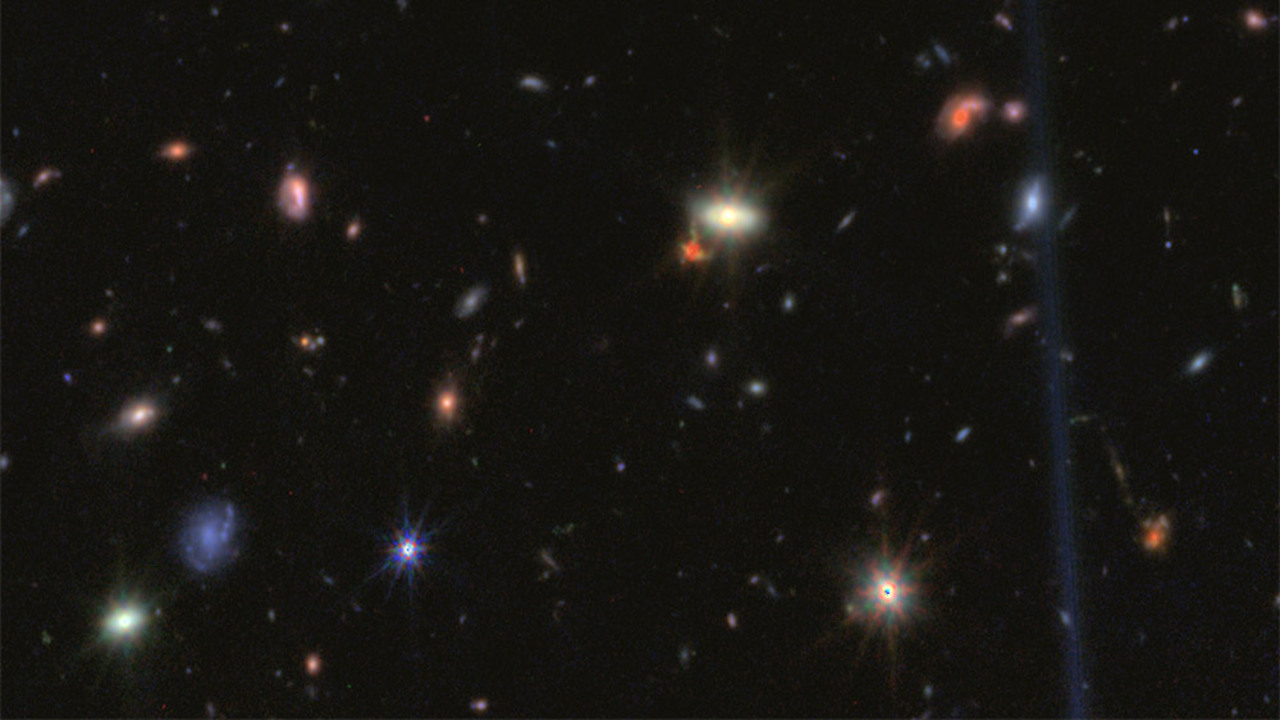 immagine del telescopio James Webb che mostra diversi piccoli punti rossi